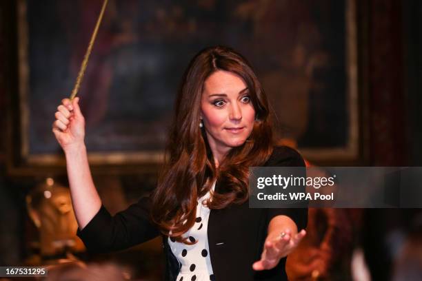 Catherine, Duchess of Cambridge waves her wand on the set used to depict Diagon Alley in the Harry Potter Films during the Inauguration Of Warner...