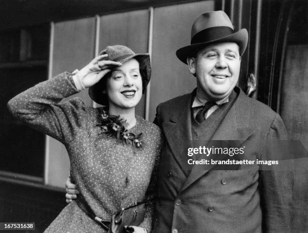 British actor and director Charles Laughton and his wife Elsa Lanchester . Waterloo station/London. March 3th 1934. Photograph. Der britische...