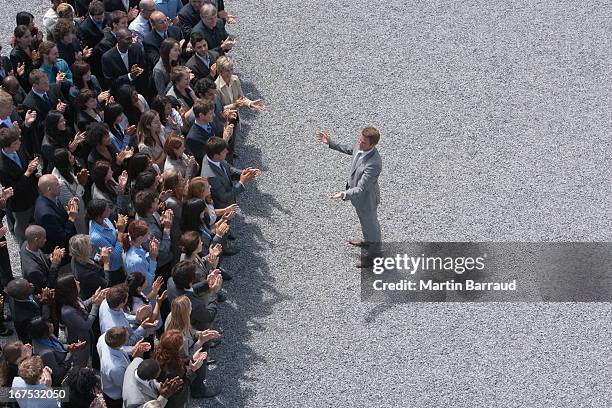 businessman addressing clapping crowd - politicians stockfoto's en -beelden