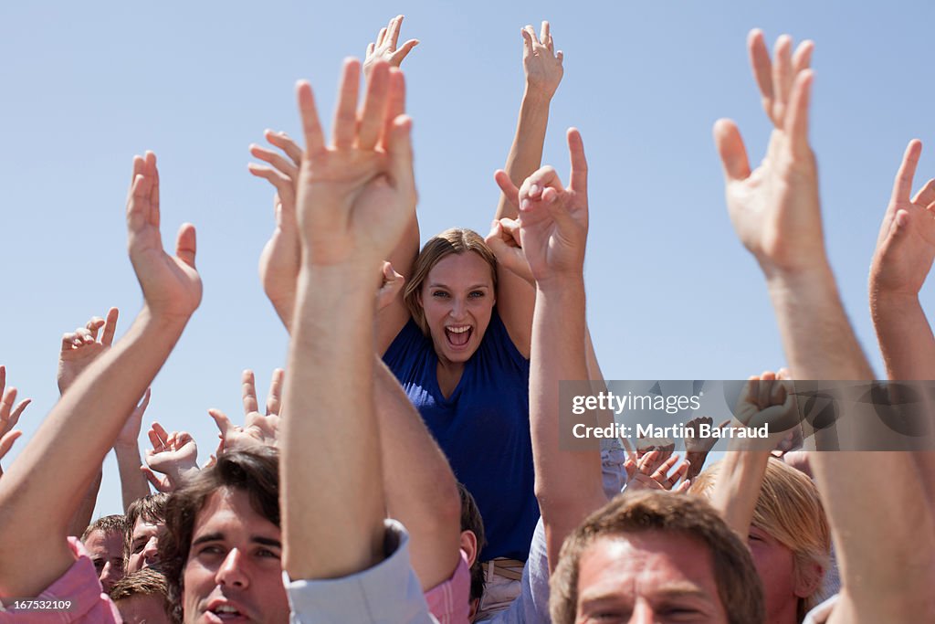 Cheering crowd with arms raised