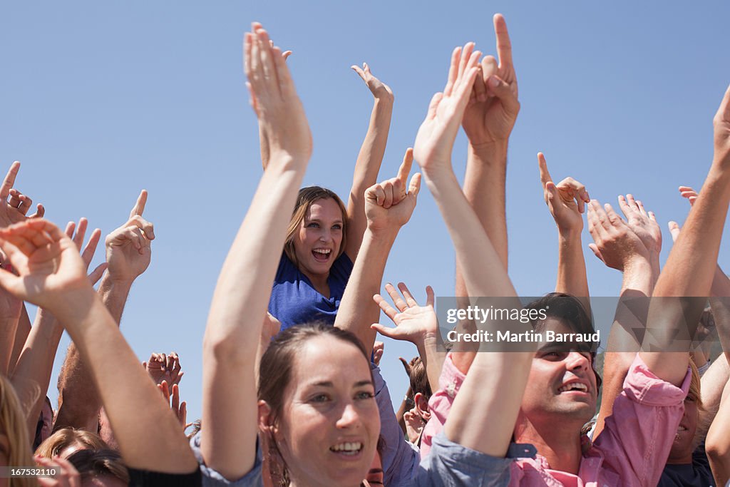 Cheering crowd with arms raised