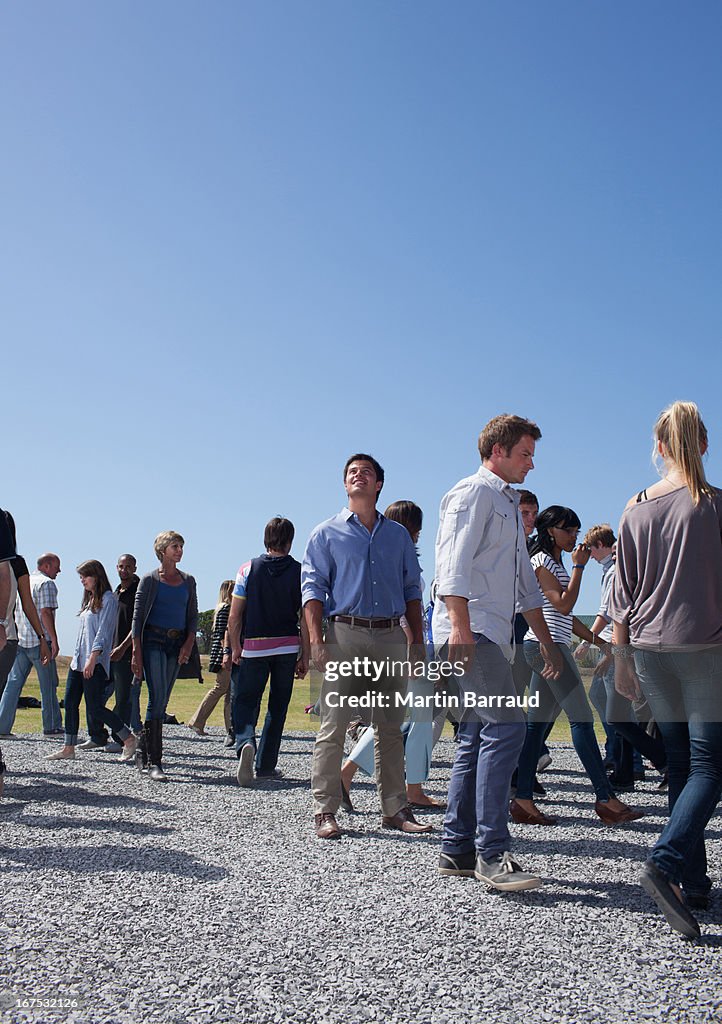 Man looking up in center of crowd of walking people