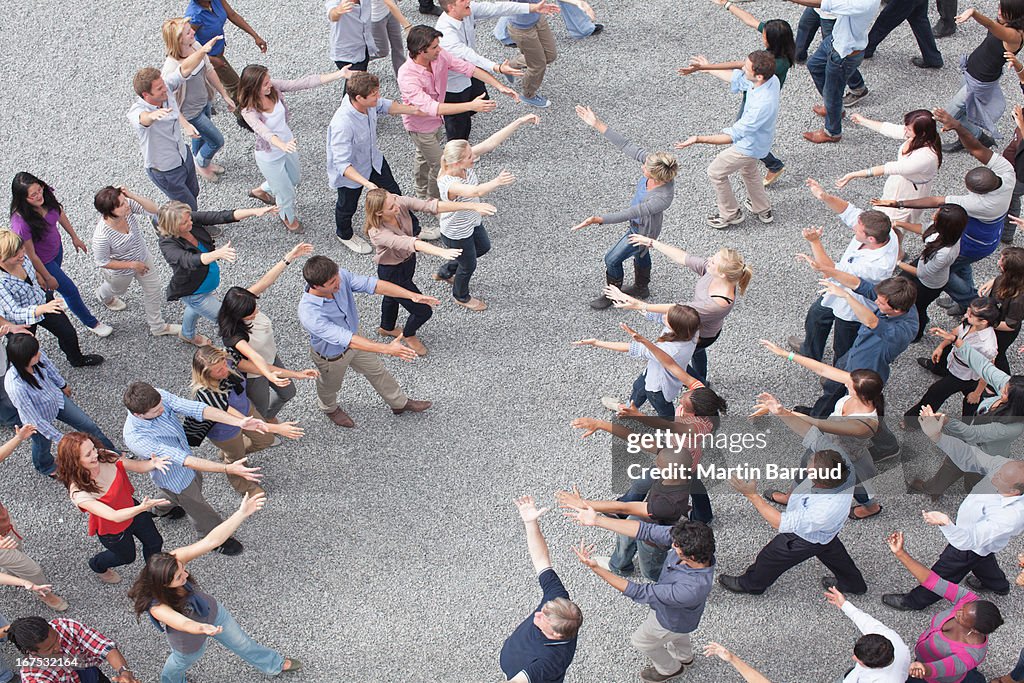 People extending arms to each other in crowd