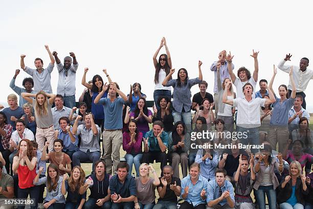 group of spectators cheering - juichen stockfoto's en -beelden