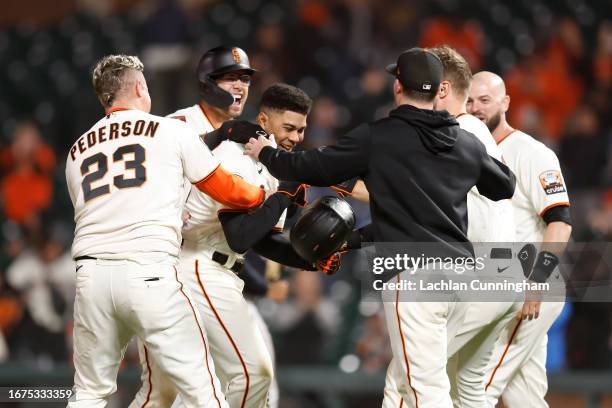 LaMonte Wade Jr. #31 of the San Francisco Giants celebrates with teammates after hitting a walk-off RBI single in the bottom of the tenth inning...