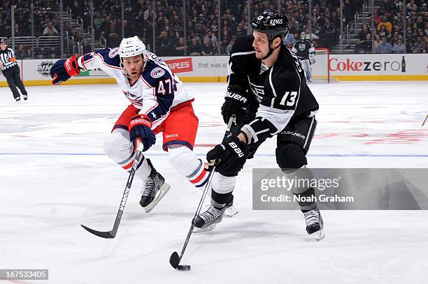 Kyle Clifford of the Los Angeles Kings skates with the puck against Dalton Prout of the Columbus Blue Jackets at Staples Center on April 18, 2013 in...