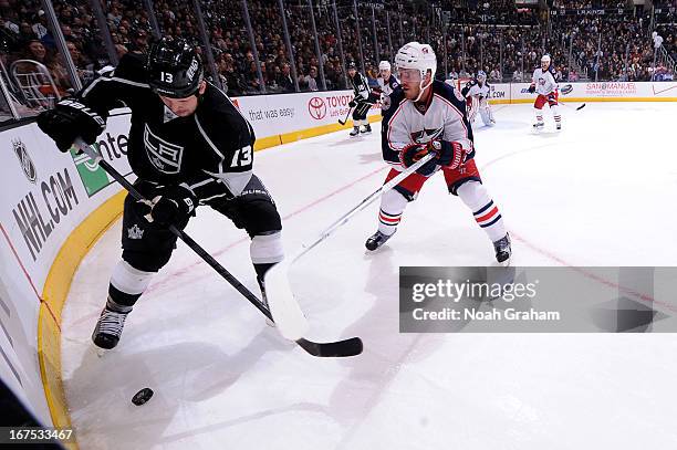 Kyle Clifford of the Los Angeles Kings skates with the puck against James Wisniewski of the Columbus Blue Jackets at Staples Center on April 18, 2013...