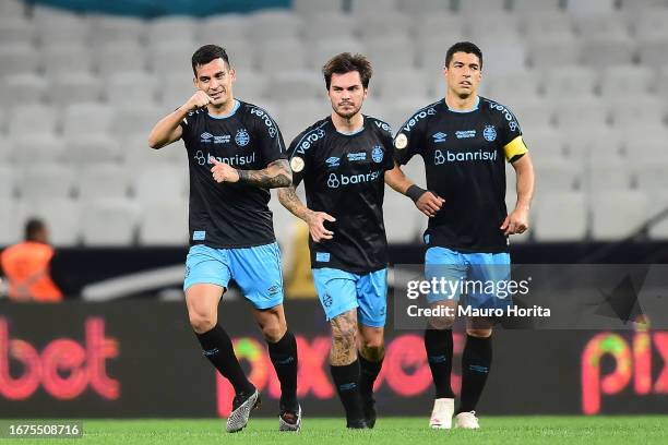 Franco Cristaldo of Gremio celebrates with teammates Nathan and Luis Suárez after scoring the team's second goal during a match between Corinthians...