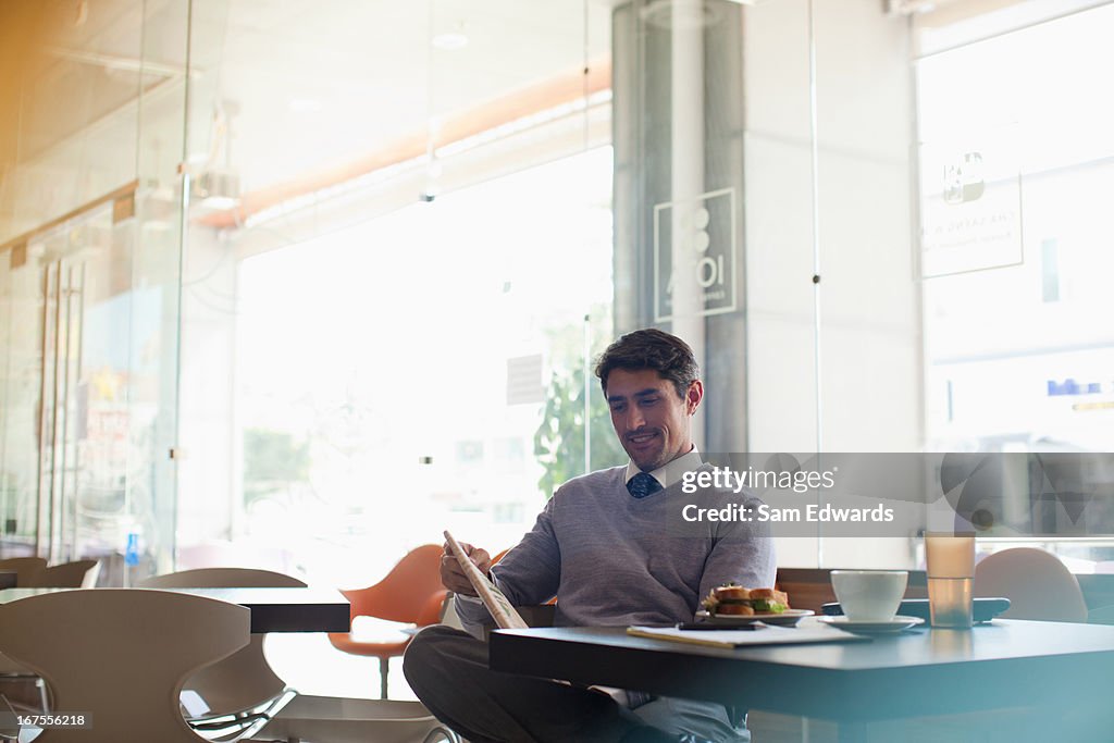 Businessman reading newspaper in cafe