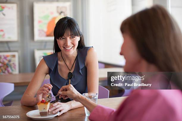 women sharing dessert in cafe - mom head in hands stock pictures, royalty-free photos & images