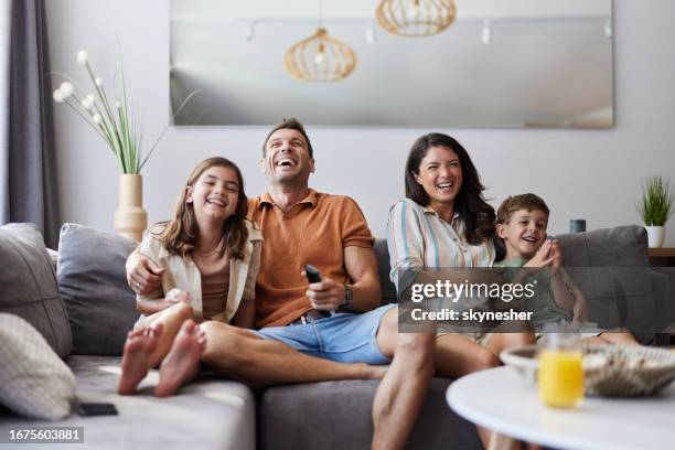 cheerful family enjoying in a movie at home. - family sofa stock pictures, royalty-free photos & images