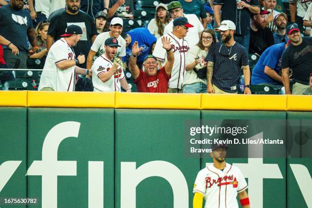 Fans retrieve a home run hit by Bryce Harper of the Philadelphia Phillies during the third inning against the Atlanta Braves at Truist Park on...