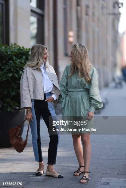 Josephine Kröger wearing mint colored knee length long sleeve SoSue dress and black open Celine sandal with straps and Sue Giers wearing Celine bag,...