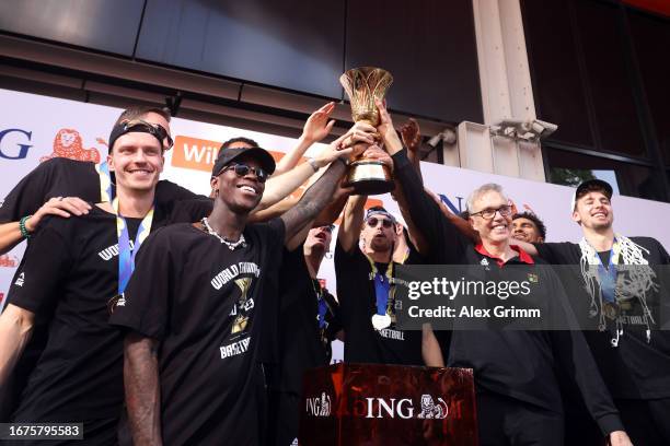 Head coach Gordon Herbert, team captain Dennis Schroeder and teammates celebrate with the trophy during a reception for the German National...