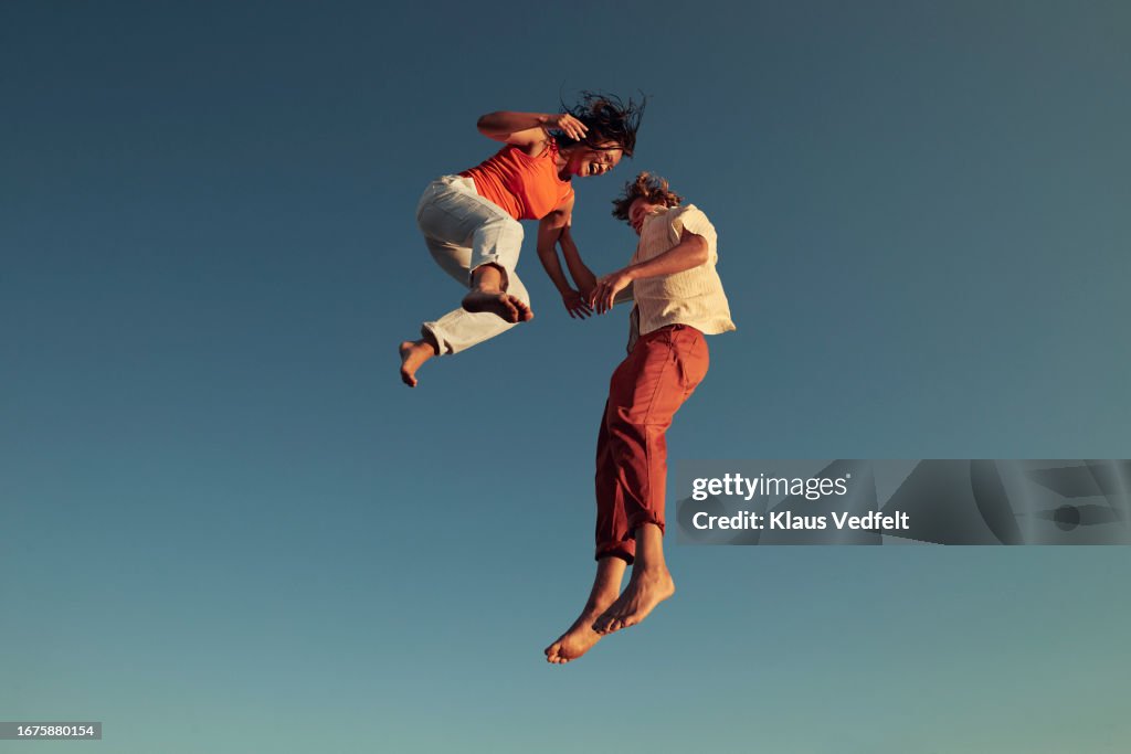 Cheerful friends jumping high up in mid-air
