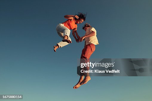 Cheerful friends jumping high up in mid-air Cheerful friends jumping high up in mid-air