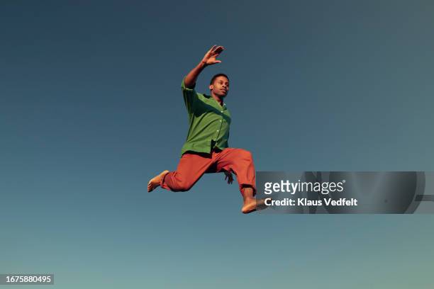 man jumping in mid-air while doing acrobat - copy space stock pictures, royalty-free photos & images