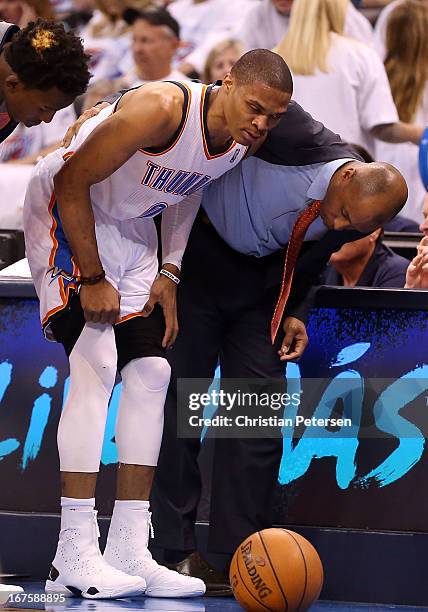 Russell Westbrook of the Oklahoma City Thunder is looked at by a trainer after a leg injury during Game Two of the Western Conference Quarterfinals...