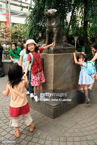 Children playing around Hachiko. The statue of Hachiko in front of Shibuya Station in Tokyo is one of the most famous and popular meeting places in...