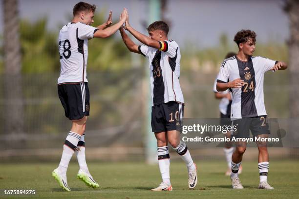 Captain Tom Bischof from U19 Germany celebrates scoring their opening goal with teammates Dzenan Pejcinovic and Luca Marino during the international...