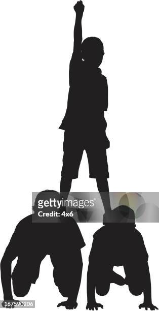 boys standing on the back of his brothers - family fun indoor stock illustrations