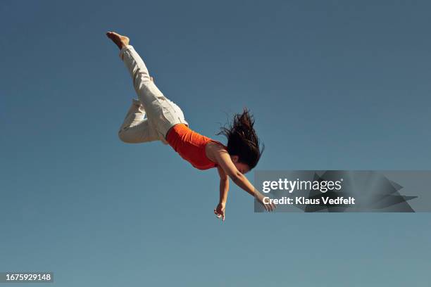 carefree young woman levitating against clear blue sky - carefree fotografías e imágenes de stock