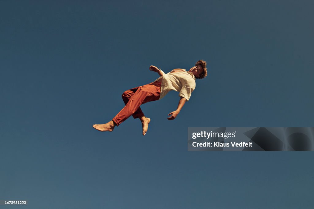 Full length of young man flying in mid-air