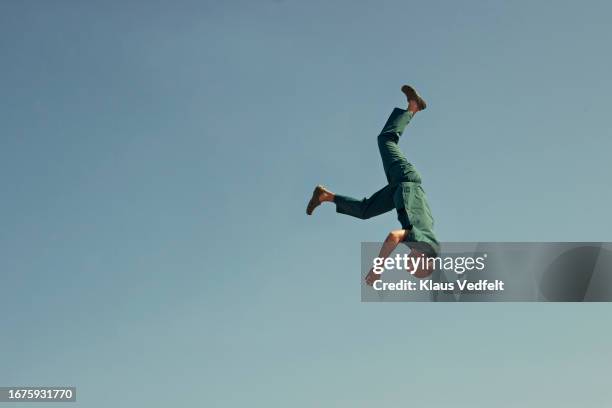 upside down male healthcare worker against blue sky - auf-den-kopf-gestellt stock-fotos und bilder