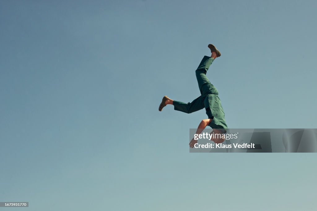Upside down male healthcare worker against blue sky