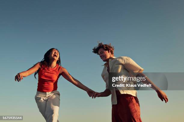 happy friends enjoying against clear blue sky - blue sky friends photos et images de collection