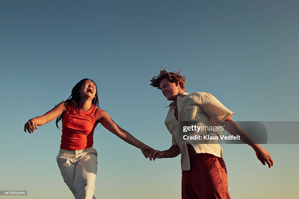 Happy friends enjoying against clear blue sky