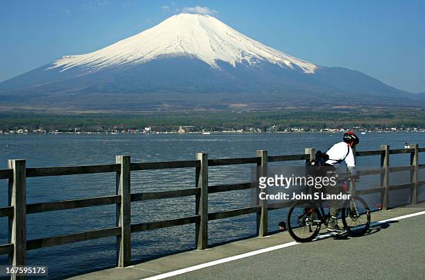Biking past Mt Fuji along the shores of Lake Yamanaka or Yamanaka-ko, one of the Fuji Five Lakes in Yamanashi Prefecture in Japan..