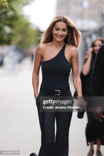 Rita Ora was seen wearing a grey top with only one stripe, grey balloon pants with a black belt and a black bag outside before the Michael Kors...