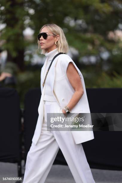 Mary Lawless Lee was seen wearing dark Loewe sahdes, white trousers, a black top with turtle neck, an armless vest, a black Chanel bag and golden and...