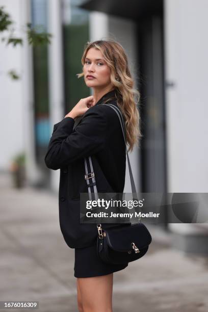 Chloe Lecareux was seen wearing a black bra, a black skirt with the logo from Michael Kors, a black blazer, a black bag with golden ornaments and...