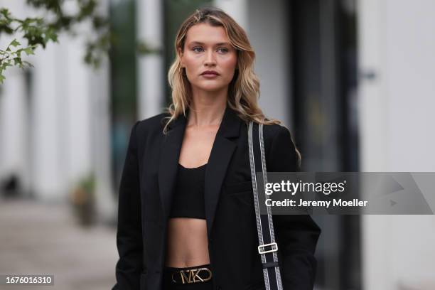 Chloe Lecareux was seen wearing a black bra, a black skirt with the logo from Michael Kors, a black blazer, a black bag with golden ornaments and...