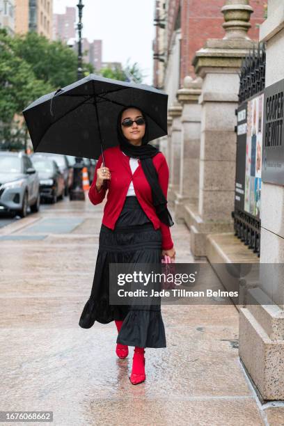 Guest is seen wearing a red top, black skirt and red sandals outside the Sandy Liang show during New York Fashion Week at Cooper Hewitt on September...