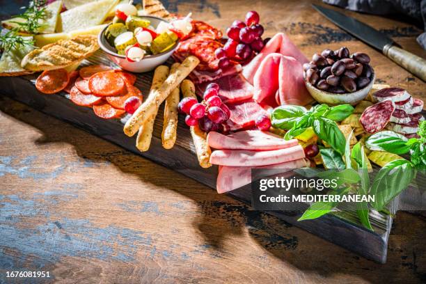 mediterranean appeticer antipasto wooden board, cold cuts meat charcuterie and cheese - charcuterie stockfoto's en -beelden