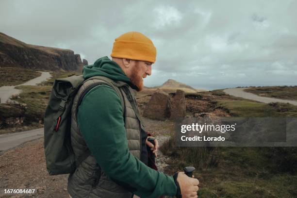 male hiker enjoying the beautiful countryside landscape of the highlands in scotland - hiking stock pictures, royalty-free photos & images