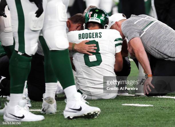 Quarterback Aaron Rodgers of the New York Jets is attended to after being sacked by Leonard Floyd of the Buffalo Bills and suffering an apparent...