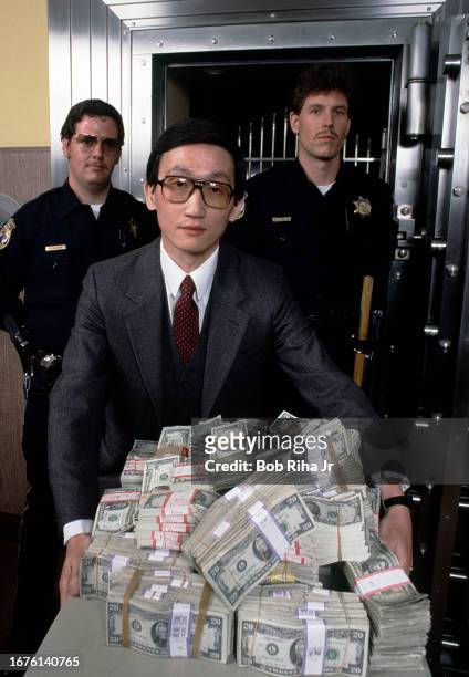 Federal Deposit Insurance Corporation Liquidator Herbert Chin with money seized from an insolvent Golden Valley Bank vault, March 22, 1985 in...