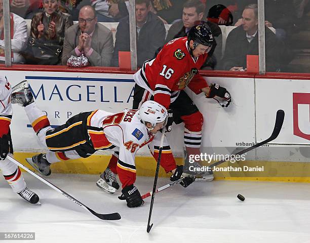 Carter Bancks of the Calgary Flames hits the ice as he battles with Marcus Kruger of the Chicago Blackhawks at the United Center on April 26, 2013 in...