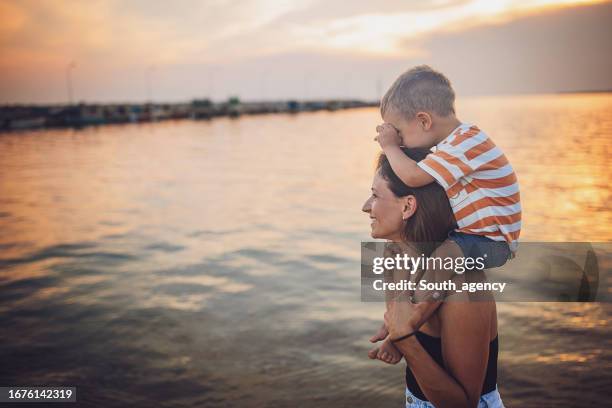 woman and son on the beach - carrying on shoulders stock pictures, royalty-free photos & images
