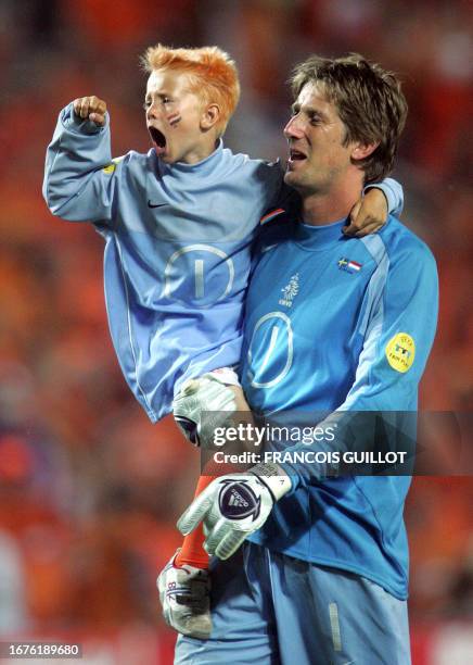 Dutch goalkeeper Edwin Van Der Sar celebrates with his child, 26 June 2004 at the Algarve stadium in Faro, at the end of the Euro 2004 quarter final...