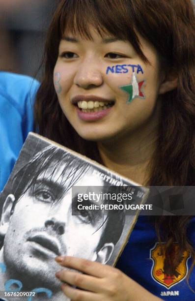 Japanese fan of Italy's No. 13, defender Alessandro Nesta, displays a poster of her favorite player 13 June, 2002 before match 43 group G of the 2002...