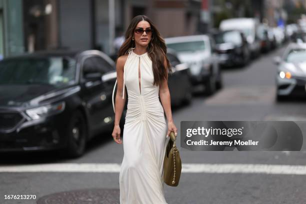 Camila Coelho is seen outside Proenza Schouler show wearing brown sunnies, long white Proenza Schouler dress with ruffled waist and a kaki colored...