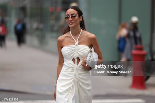 Tamara Kalinic is seen outside Proenza Schouler show wearing silver hardware round sunnies, a laced around white Proenza Schouler dress with open cut...