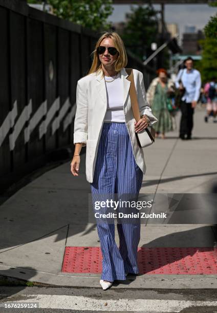 Lisa Aiken is seen wearing a white blazer, white top, blue and white striped pants and white shoes outside the Michael Kors show during NYFW S/S 2024...