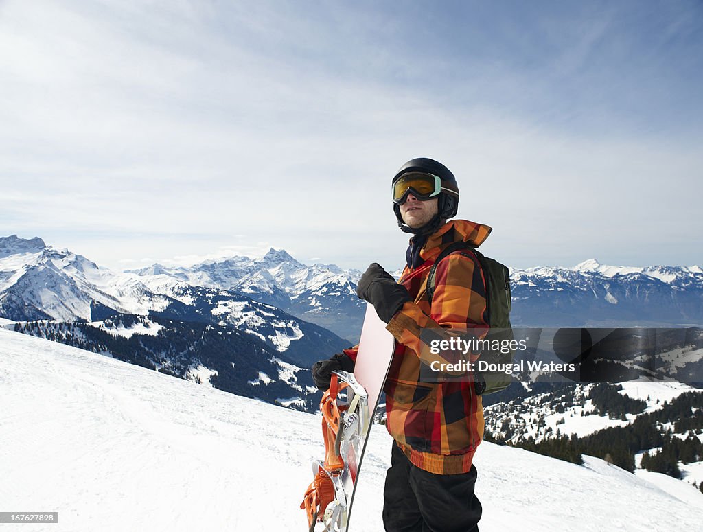 Snowboarder in ski wear in Swiss Alps.