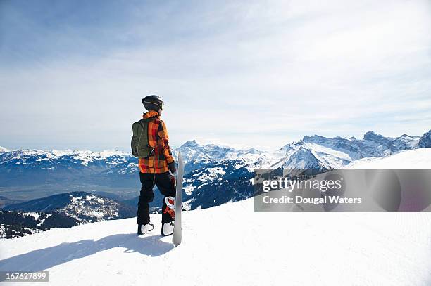 snowboarder looking across mountain range. - snowboard stockfoto's en -beelden